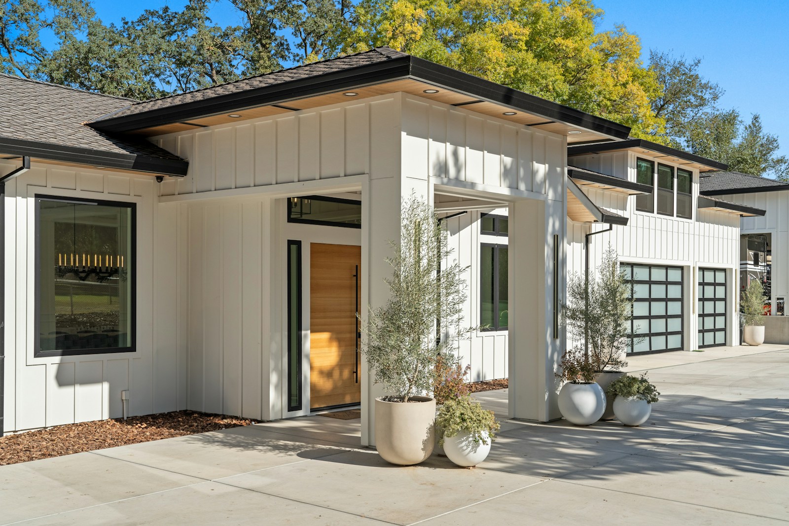 Contemporary home with a wood front door and glass garage doors