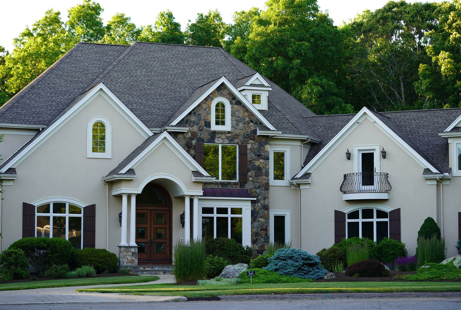 A large house with a stone-accented facade and landscaped front garden.