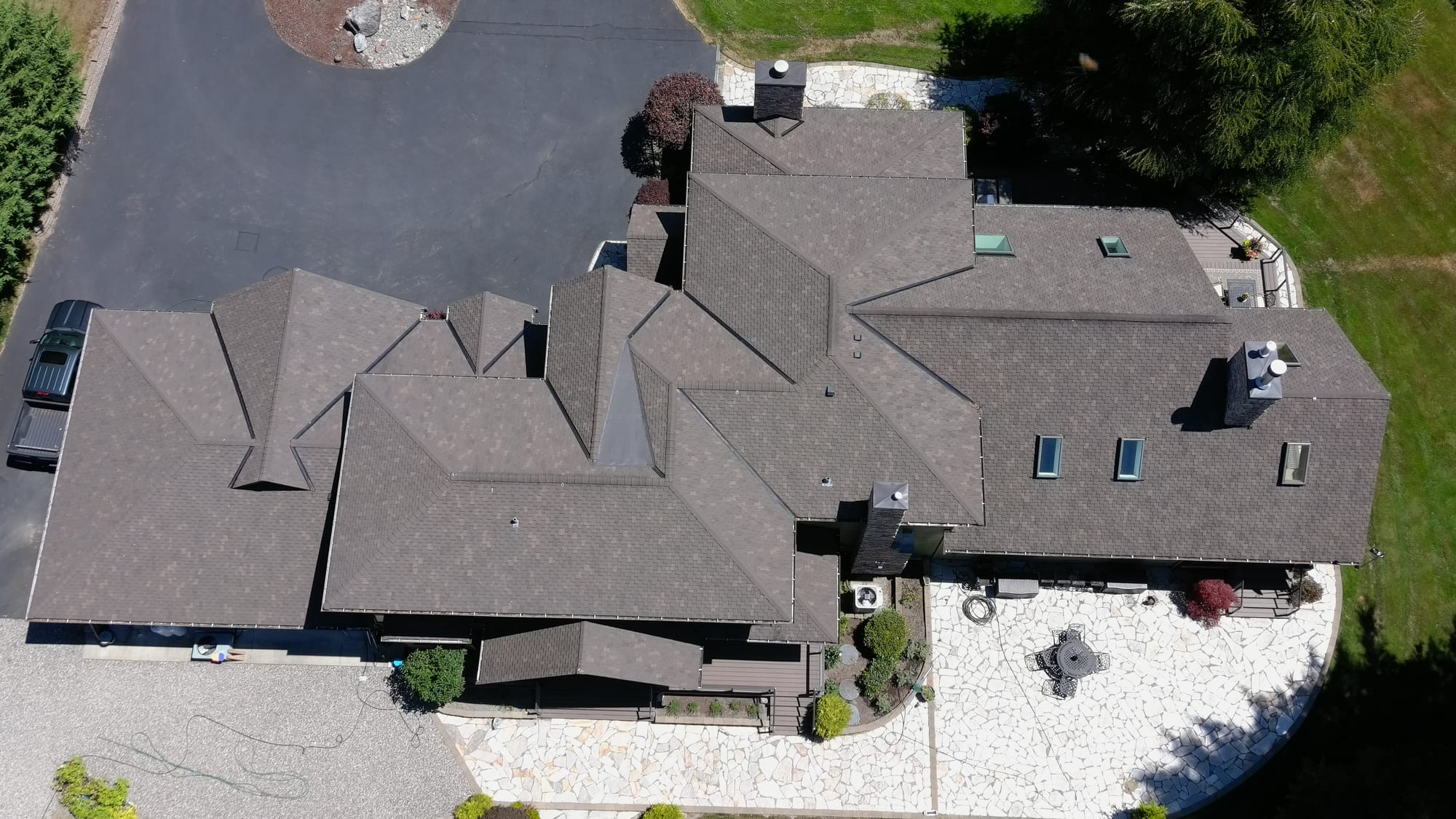 Asphalt roofing across a complex residential roofline