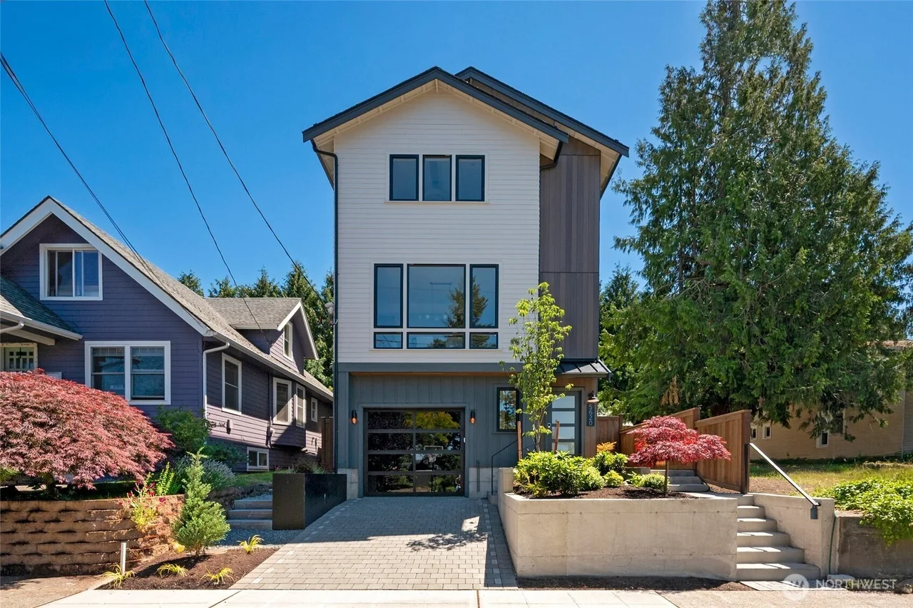 Front exterior of 5620 6th Avenue NW, showing the three-story home, garage, entry steps and landscaping